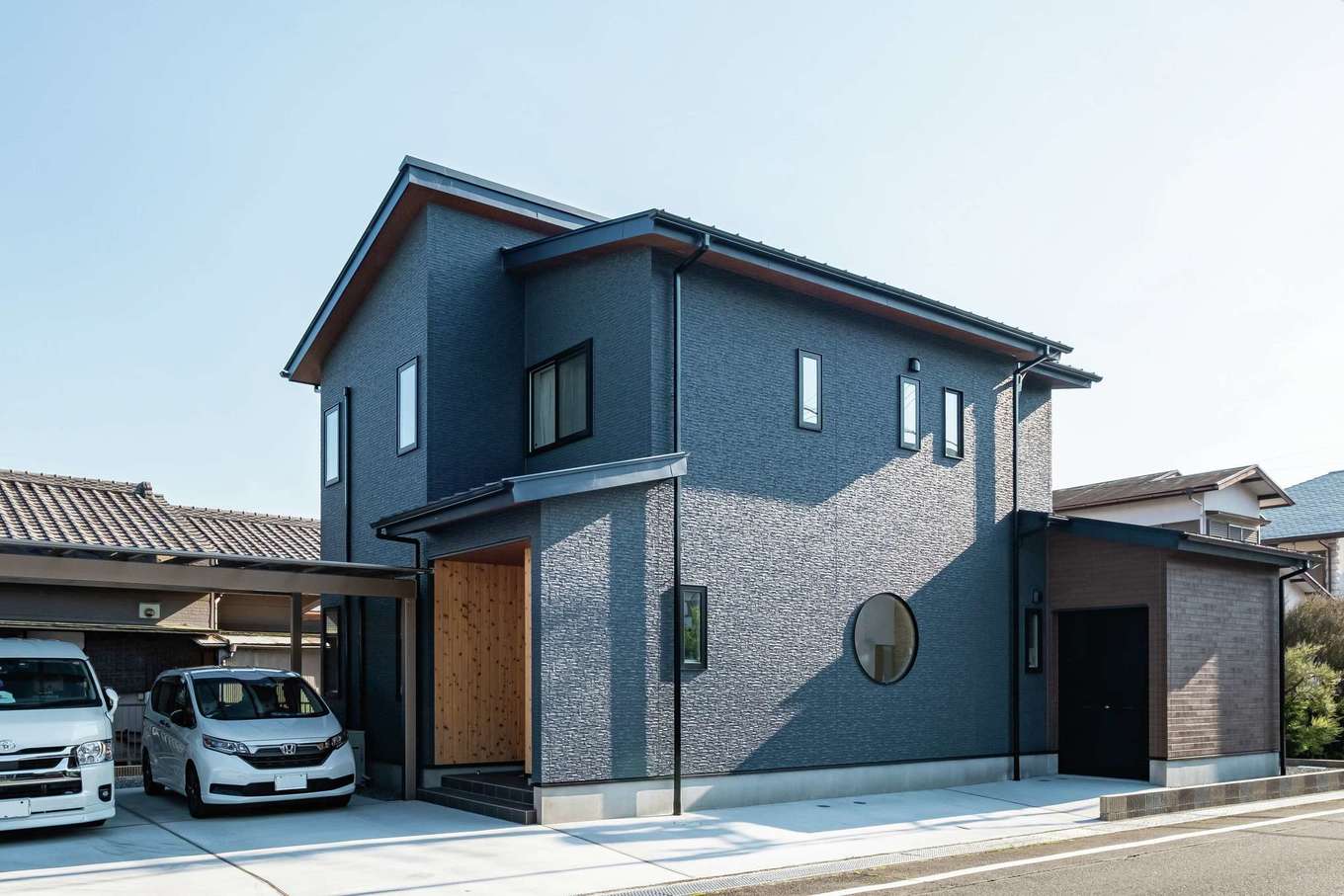 ぽっくハウス【リプルス】【デザイン住宅、趣味、間取り】1階の丸窓が近隣のランドマークに。横長の敷地を活かして、車のガレージ＋インナーバイクガレージも実現