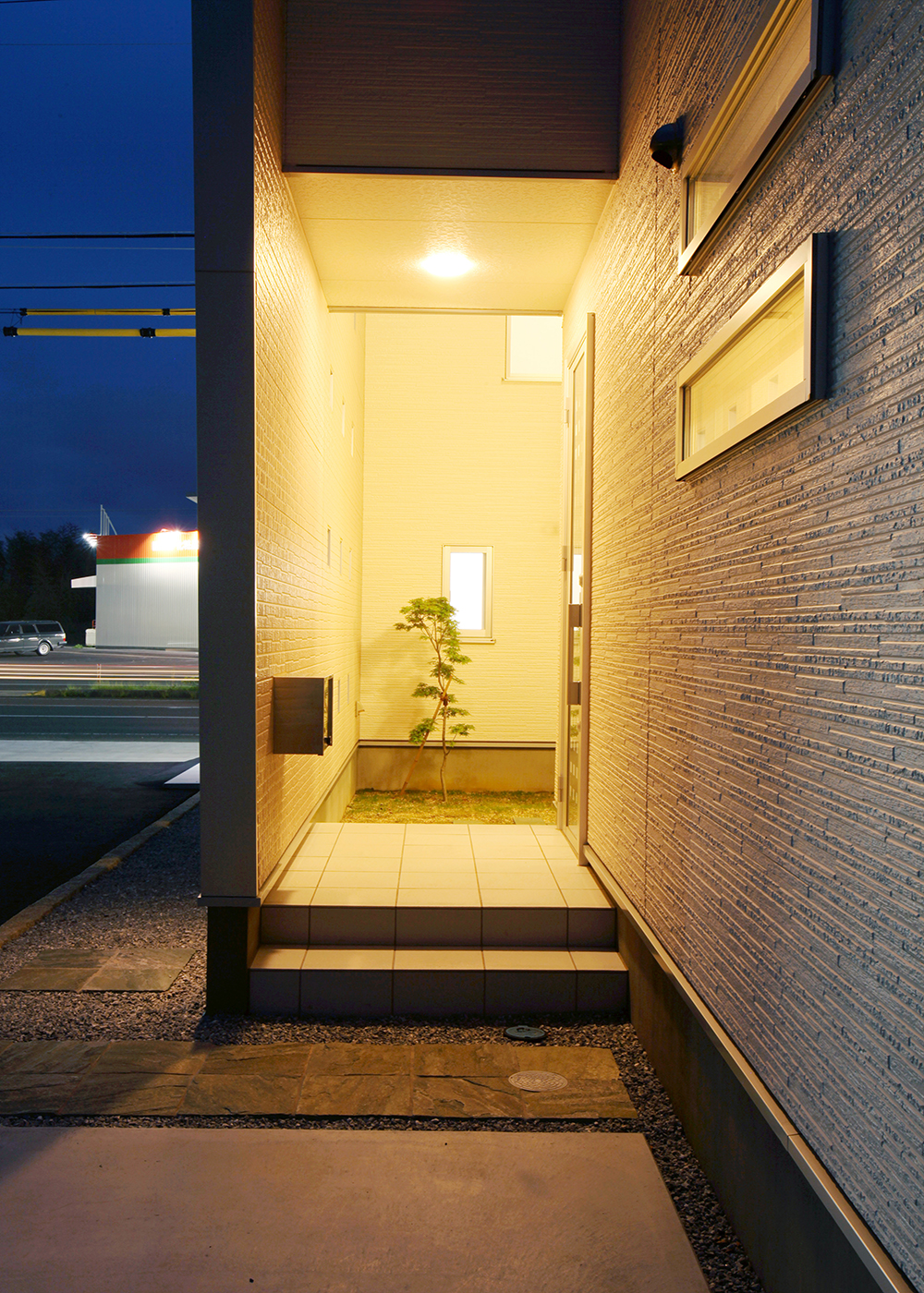 丸昇彦坂建設【デザイン住宅、間取り、インテリア】飾り壁の玄関アプローチは、住人の帰りを温かく迎え入れてくれるだろう