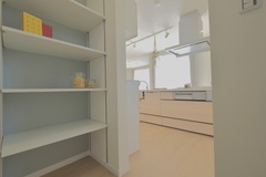 キッチンに隣接するパントリーは、食品や雑貨を整理整頓できる使い勝手の良いスペース。シンプルな棚が収納力を引き立てる。