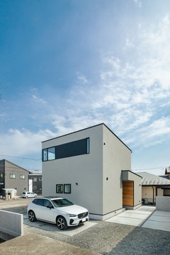 シンプルで洗練されたデザインの外観。モノトーンカラーが際立ち、庭や駐車スペースとも調和している。