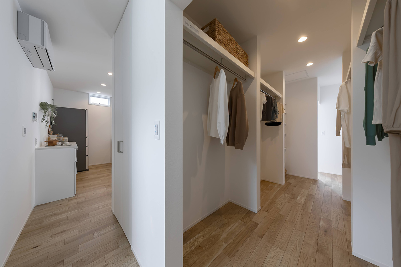 PG HOUSE（ピージーハウス）【浜松市中央区曳馬6-19-5・モデルハウス】玄関ホールから洗面スペースへウォークスルーできるファミリークローゼット。玄関、ランドリー、各部屋からアクセスしやすく、衣類や荷物の出し入れがスムーズに。衣類や荷物をまとめて収納できるので部屋が散らからず、家事の負担も軽減できる