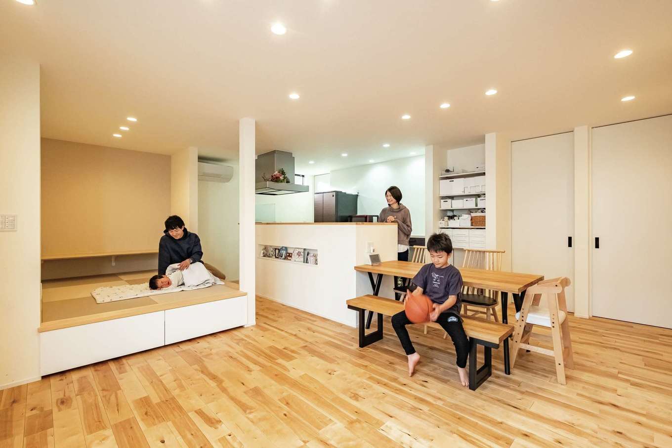 ARCHITECT STUDIO TEGOKORO （遠藤建築店）【子育て、間取り、平屋】リビングの床は素足で歩いても冷たさを感じない無垢のカバ。気持ちがいいので、家族全員で床に寝そべって筋トレを楽しむことも。畳コーナーは次男のお昼寝スペースにぴったり。キッチンからも目が届くから安心。リビングには勉強用カウンターも造作した