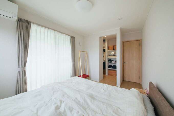 寝室のウォークインクローゼットは入り口付近に壁面収納も採用。出入り口のドアから近いので、片付けもしやすい。2階の壁は塗り壁ではなくクロスにすることで、トータルコストも節約できている