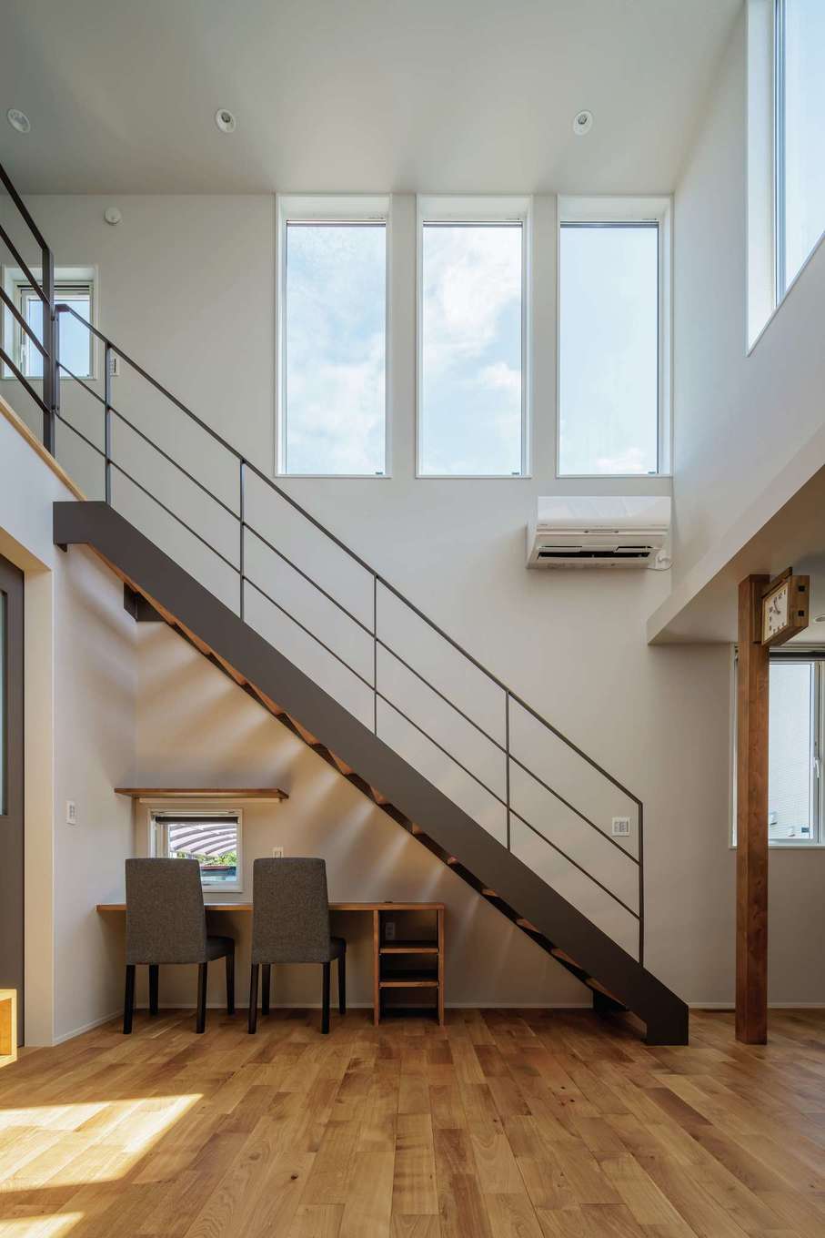 tact design firm【デザイン住宅、子育て、間取り】吹抜けの白い空間にグレーの鉄骨階段が映える。階段下はスタディコーナーとして活用