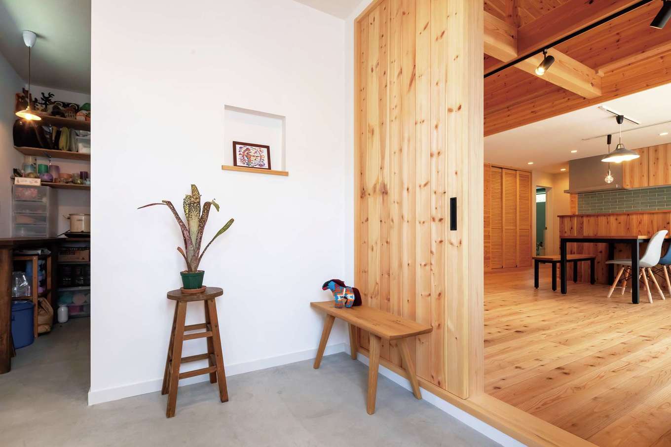 フジモクの家（富士木材）【デザイン住宅、自然素材、平屋】シンプル＆ナチュラルな土間玄関。天井まで届くハイドアは壁と同じパイン材で、空間に一体感が生まれた。奥はキャンドル作家でもある奥さまの
アトリエ