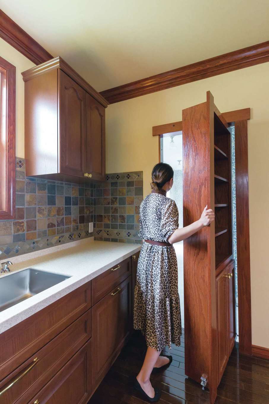 セルコホーム浜松（オバタケイ）【デザイン住宅、輸入住宅、インテリア】隠し扉になっているキッチンの棚。キッチンからユーティリティスペース、洗面、玄関と回遊でき、動線も便利