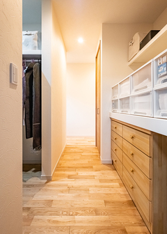 長い廊下を活かして、ウォークスルータイプの大容量クローゼットを確保した。平屋で不足しがちな収納量も十分
