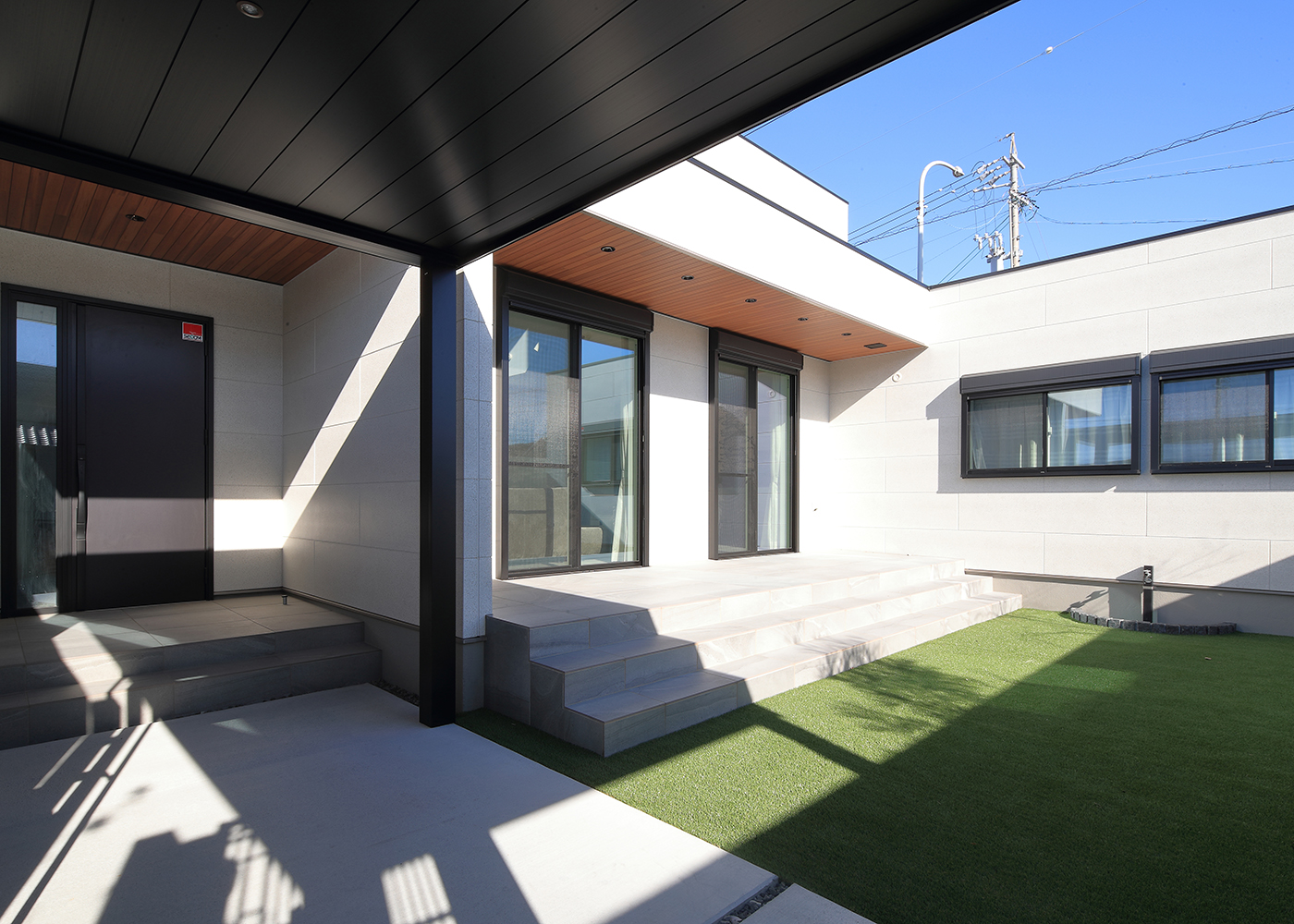 TOZAKI HOME 戸﨑建設　【デザイン住宅、間取り、インテリア】帰宅時には緑の中庭を眺めながら、アプローチを進んで玄関へ。建物をL字に配置して周囲からの視線を遮るプライベート空間を実現した