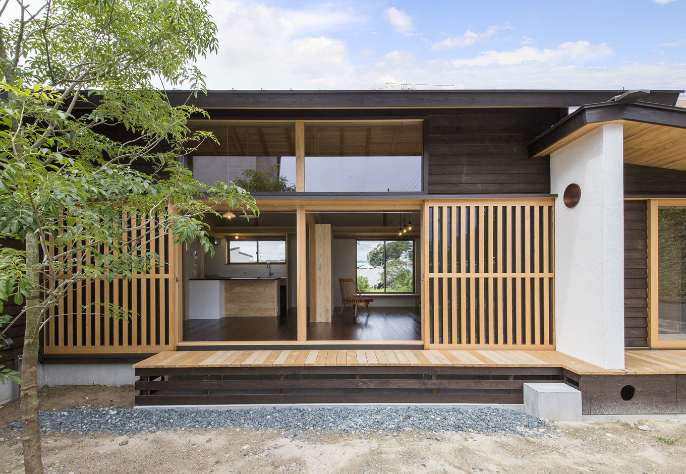 石牧建築【収納力、自然素材、建築家】リビングに全開口の引き戸を採用し、室内をより広く見せる。格子網戸は多少室内が暗くなっても、日射遮蔽に大いに役立つ。格子網戸は、室内からは外部がよく見えるけれど、外部からは中の様子はほとんど見えない。防犯にもなるので、夜は窓を開け、風を入れて寝ることもできる