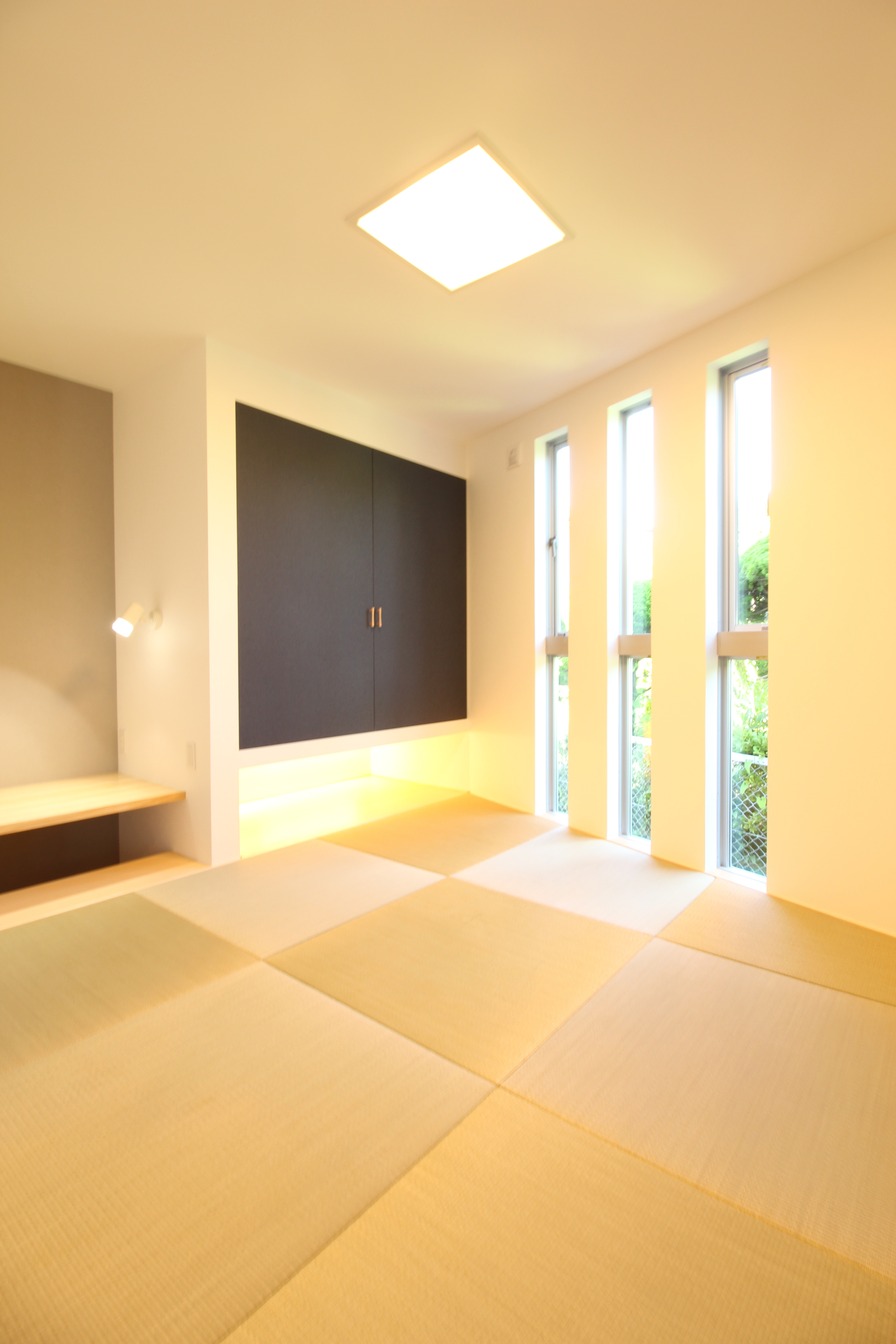 小野田産業～designers house project～｜モダンなデザインの和室空間で、壁面収納と窓が自然光を取り入れ開放感を演出している。畳の色調が落ち着きを与え、心地よい和の雰囲気を醸し出す。
