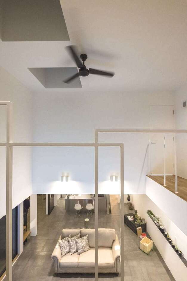 リビング上部の吹き抜けが、大空間のリビングに縦方向の開放感を与えている。吹き抜けを囲むキャットウォークの繊細なワイヤーフレームが、コンテンポラリーアートの作品のよう