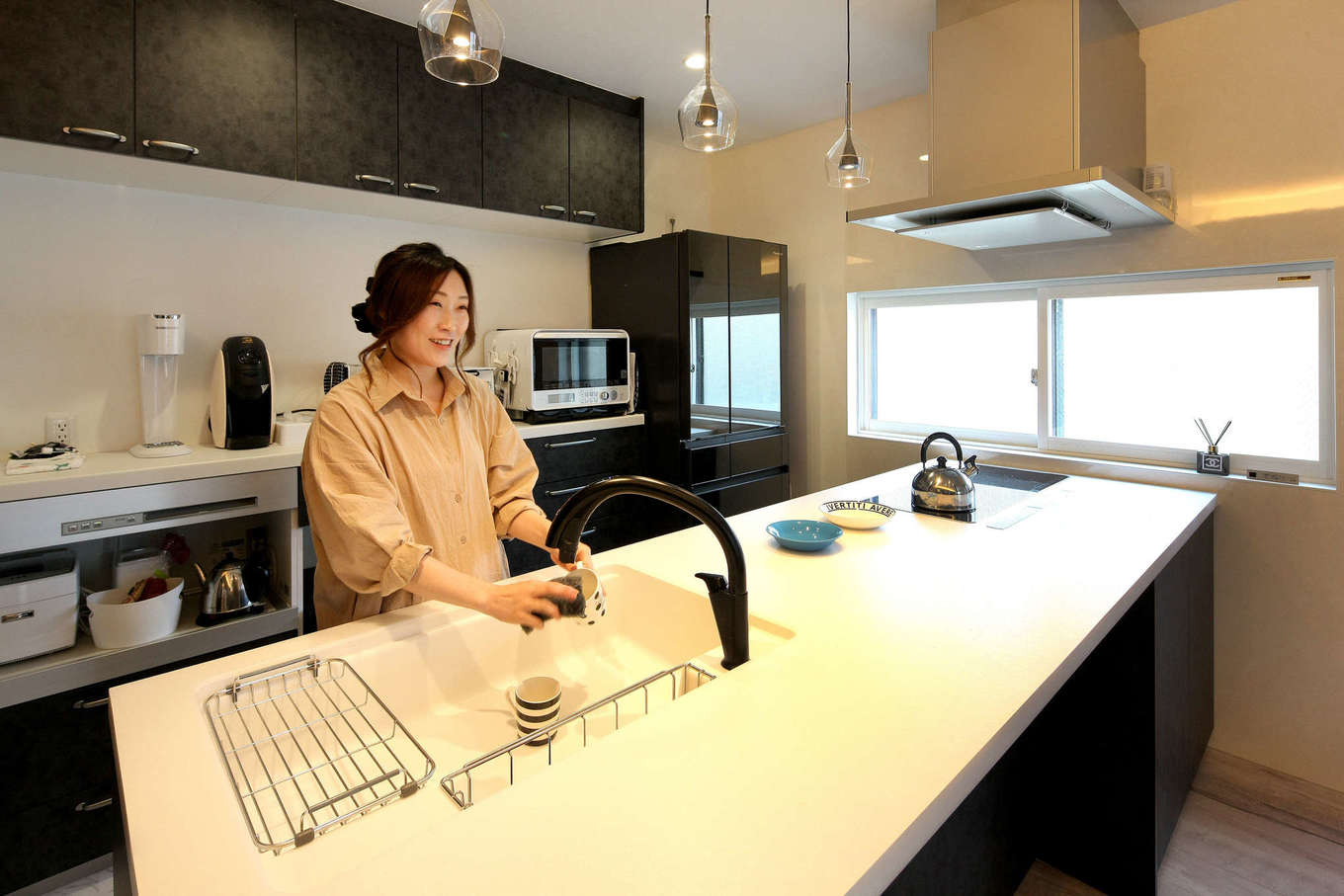ハート住いる｜奥さまお気に入りのキッチン。IHはPanasonicの3連型、黒い水栓金具はLIXIL。ワークトップを広くして、ダイニングカウンターとしても使用できるようにした