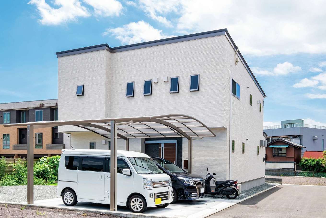 アフターホーム【子育て、趣味、高級住宅】シンプル＆モダンな外観デザイン。片流れの屋根に10kWの太陽光発電システムを搭載し、低燃費で快適な暮らしを実現した。カーポートから雨に濡れずに玄関にアクセスできる動線も考えた。線路沿いとは思えないほど室内は静か