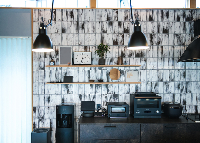 キッチン背面のカップボード。インテリアのように家電の色も統一され、アクセントクロスもおしゃれ