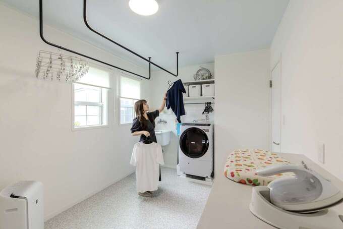 あえて2階にレイアウトしたランドリールーム。朝起きたらすぐに着替えられるし、1階に洗濯物や脱いだ衣類が散らからないなど、使ってみてメリットを感じているそう。アイロンがけできるカウンターは下が収納になっている