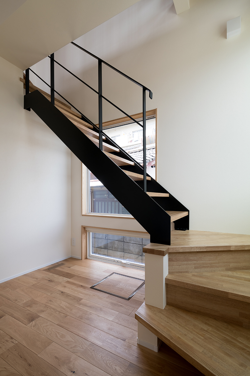 tact design firm【デザイン住宅、間取り、スキップフロア】明るい窓際にある鋼製のシンプルな階段。ウッドステップが温かみを感じさせ、モダンな雰囲気を演出