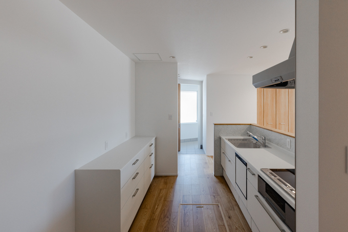 モダンなデザインのキッチン。シンプルでありながら機能的なレイアウトは、作業効率とスタイリッシュさを兼ね備えている。明るい光が差し込む快適な空間。