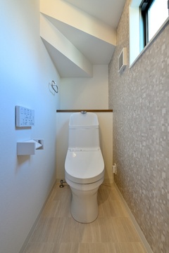 階段下のデッドスペースを有効活用した1階トイレ。背面にはカウンターを設けて、芳香剤や小物を置くこともできます。