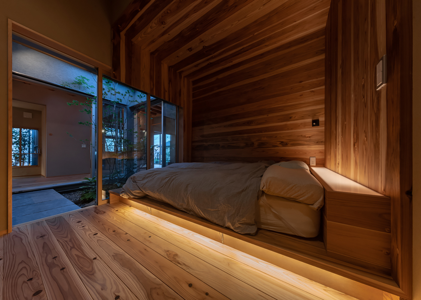 m+h（エムアンドエイチ）建築設計スタジオ【自然素材、建築家、平屋】屋久島産の杉板に囲まれた主寝室。普通の杉よりも濃い香りと高い調湿作用で、ぐっすり眠れる。毎朝「鳥のさえずりで目を覚ます」という贅沢な日々を過ごしている