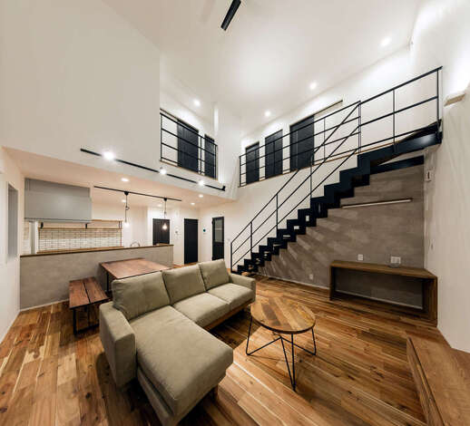 白を基調とした空間をクールなアイアンが引き締めている。階段下はワークスペース。肌触りのいいフローリングは無垢のアカシアで、経年変化も楽しみ