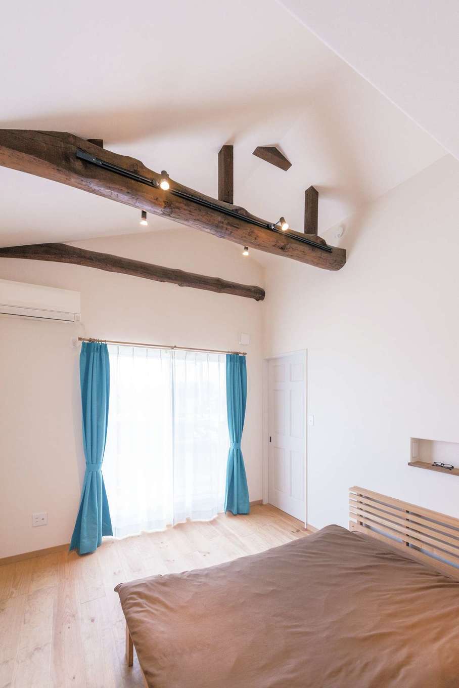 富士ホームズデザイン｜勾配天井の吹き抜けに梁を出した寝室。梁は元々あったものを活かした