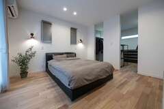 主寝室内のウォークインクローゼットは、2か所の入口（中でつながっている）にあえて扉を付けず、空間をより広く見せる。ブラケットの灯りに癒やされながら、上質な眠りに導かれていく