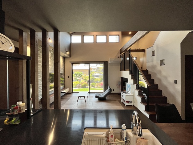 広々としたLDKが特徴の空間で、大きな窓から庭の景色が広がる。開放感あふれるデザインで、家族や友人が集まりやすいリビングスペースである。