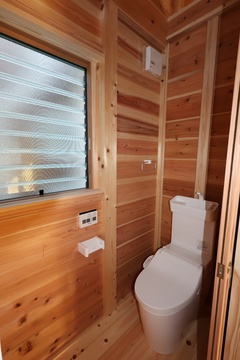 ナチュラルな木材を使用した落ち着いたデザインのトイレ。窓から採光があり、清潔感あふれる空間。