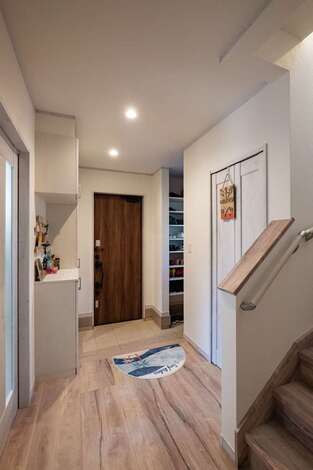 玄関には機能的なシューズクローク。壁にはどこかに使いたかったOSB合板が採用された。収納も適所に用意されている