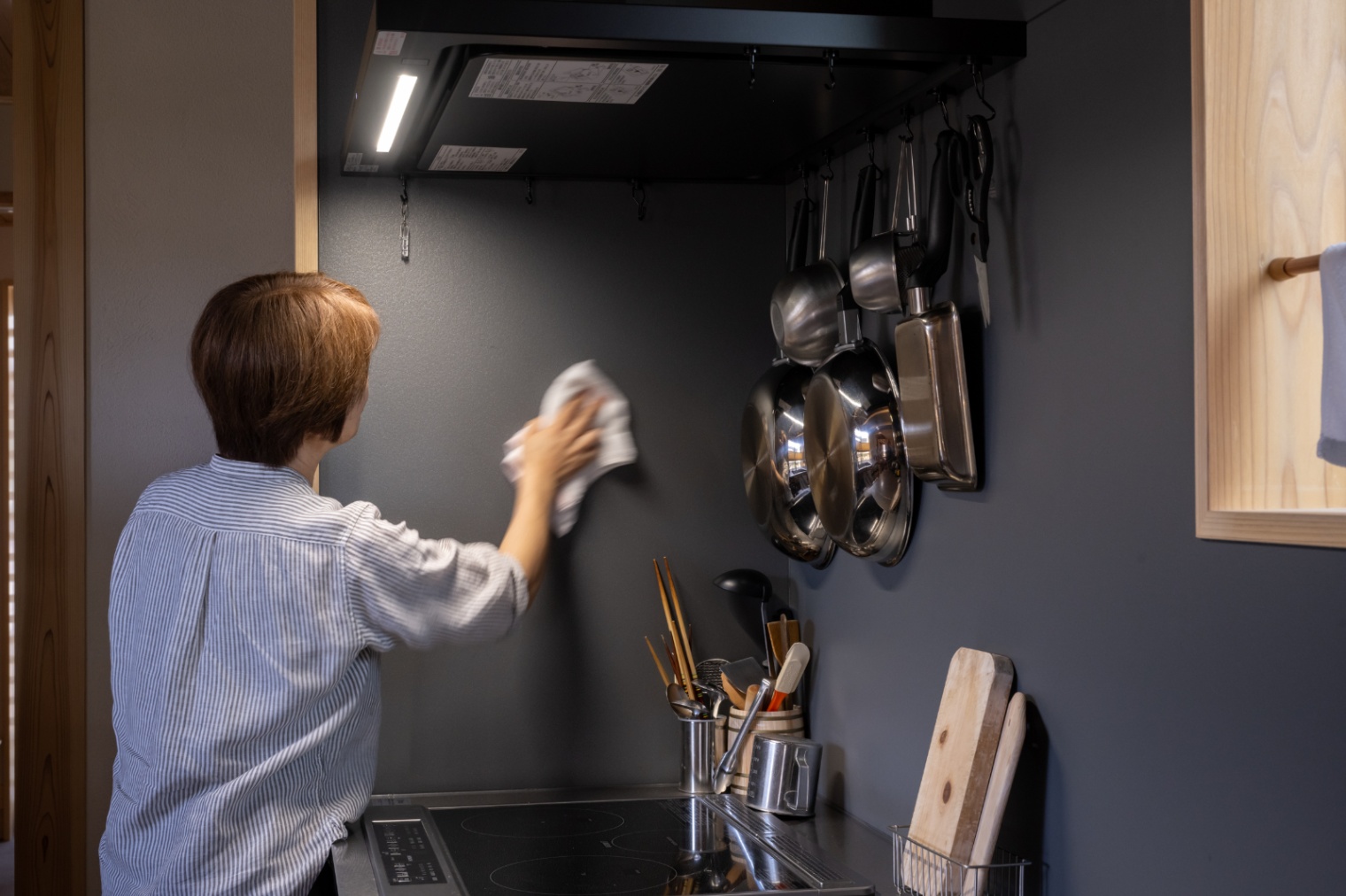 アクトホーム｜落ち着いたトーンのクリーンなキッチン。調理器具が壁面に整然と収納されており、使いやすさと美しさを兼ね備えている。