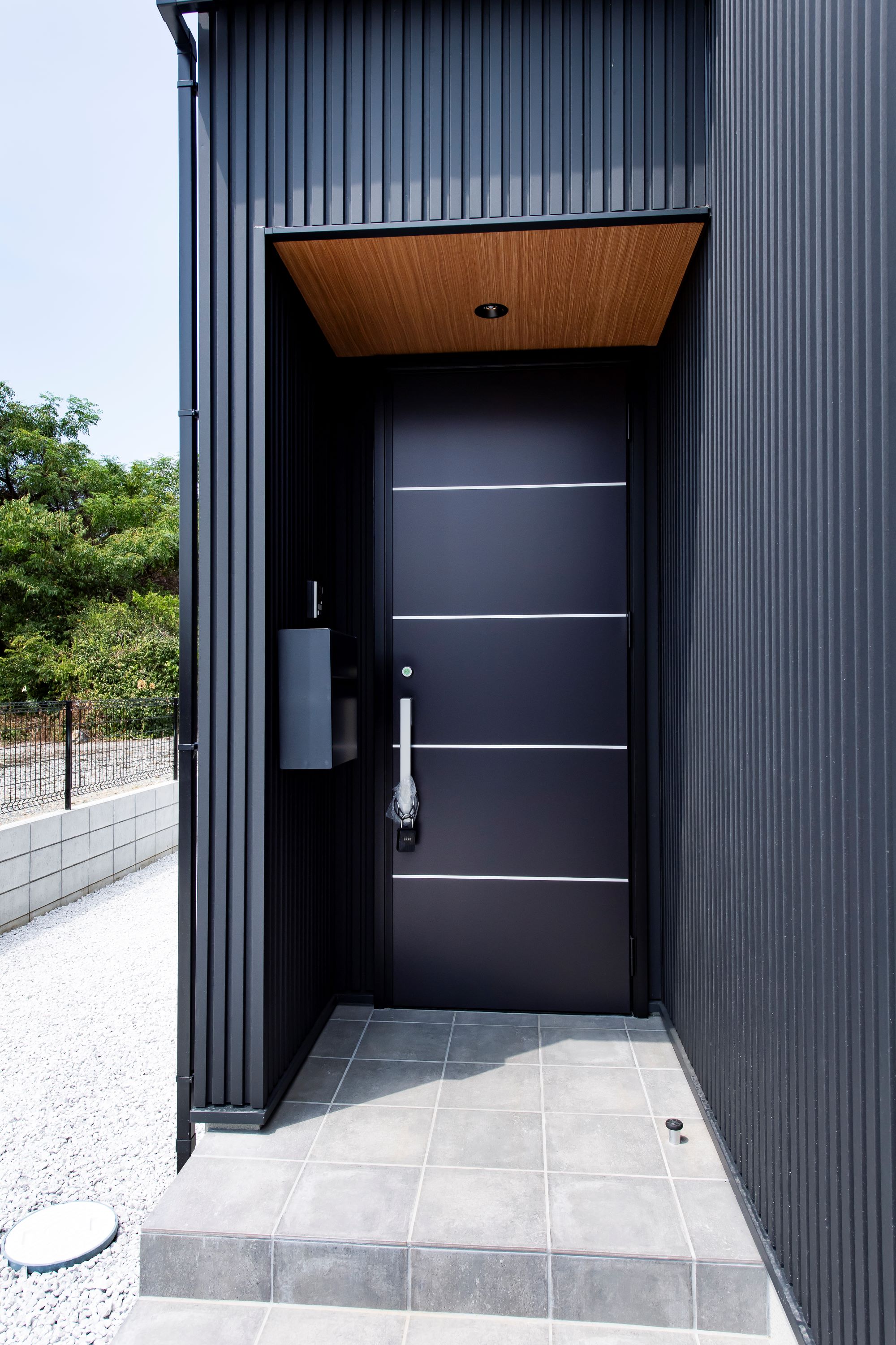 スズイチ｜シックな外観の玄関アプローチ。モダンなデザインが施されたドアが印象的で、上質な雰囲気を醸し出している。