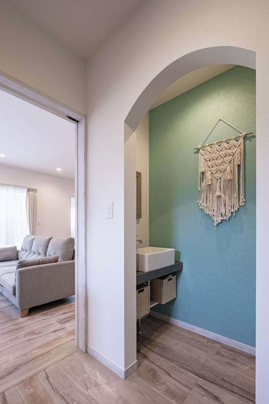 ぽっくハウス【リプルス】【デザイン住宅、狭小住宅、間取り】玄関正面のRの先は右にトイレ、左に洗面台。帰宅してすぐに手を洗えるようにした。造作洗面台の表面は鈴木さんが塗り上げたそう