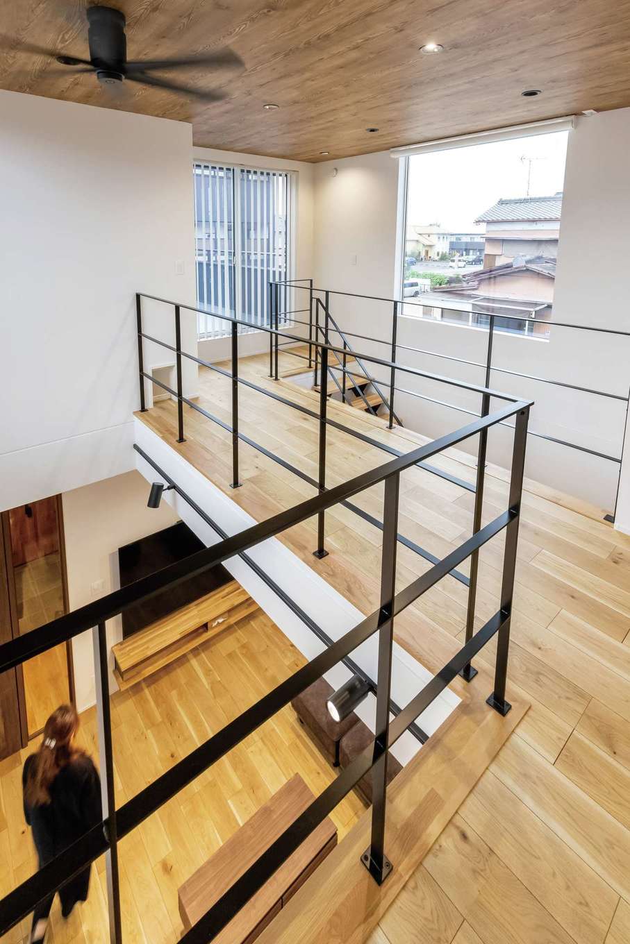 SEVEN HOUSE/セブンハウス【子育て、二世帯住宅、ペット】吹抜けには、2階の居室をつなぐ渡り廊下も。アイアンの手すりと階段を組み合わせ、デザイン性の高い空間に仕上げた