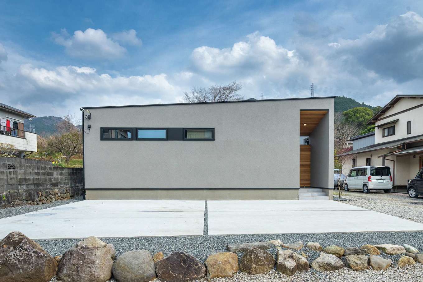 ハウスプラン（R＋house沼津・富士）【デザイン住宅、省エネ、建築家】道路側は開口部を少なくした、シンプルな外観。玄関ポーチに配したレッドシダーが印象的