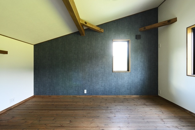 傾斜天井と木材を活かした居室。自然光が差し込み、シンプルで落ち着いた空間を提供する