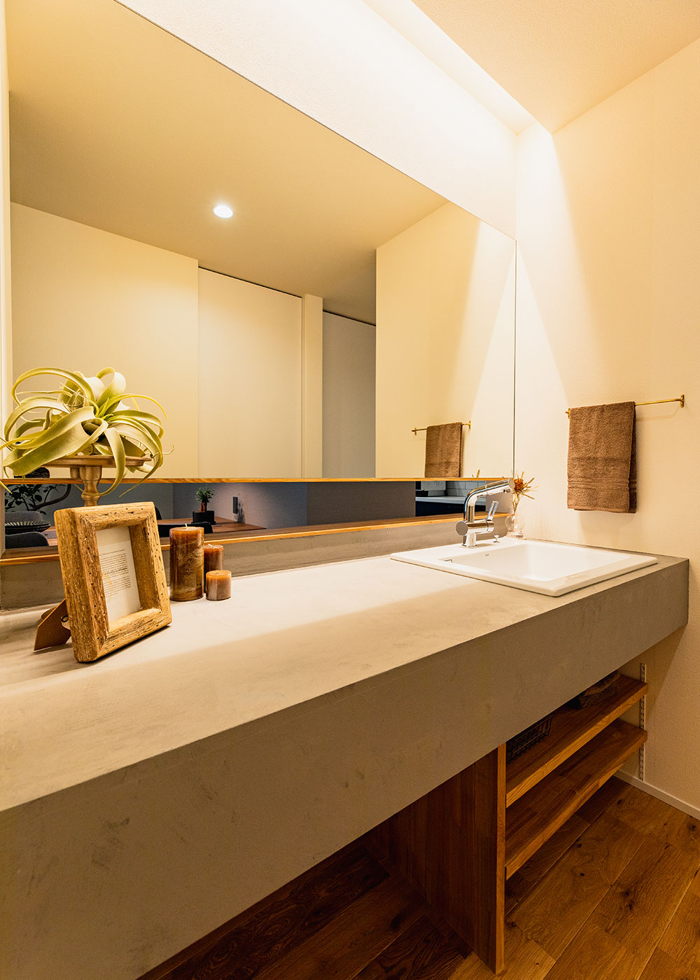 住家 JYUKA【デザイン住宅、間取り、平屋】モルタルアートの造作洗面台はスタイリッシュな雰囲気だけでなく、利便性にも大満足。大きな鏡とカウンター、さらに回遊動線が叶える周遊性によって、忙しい朝も渋滞知らず