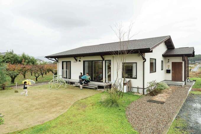 三角屋根と塗り壁の組み合わせに、緑あふれる庭が映える。夫婦であちこちの平屋を見学して決めたという軒の深さは、冬の日差しを取り込み、夏の直射日光や雨を遮る絶妙なサイズ