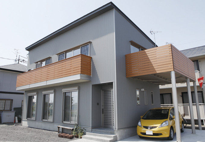 片流れのスタイリッシュな外観。木目のバルコニーがアクセントに