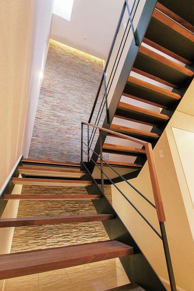 階段ホールの壁は重厚な質感の天然大理石。間接照明が凹凸のある医師の表面を立体的に浮かび上がらせてくれる