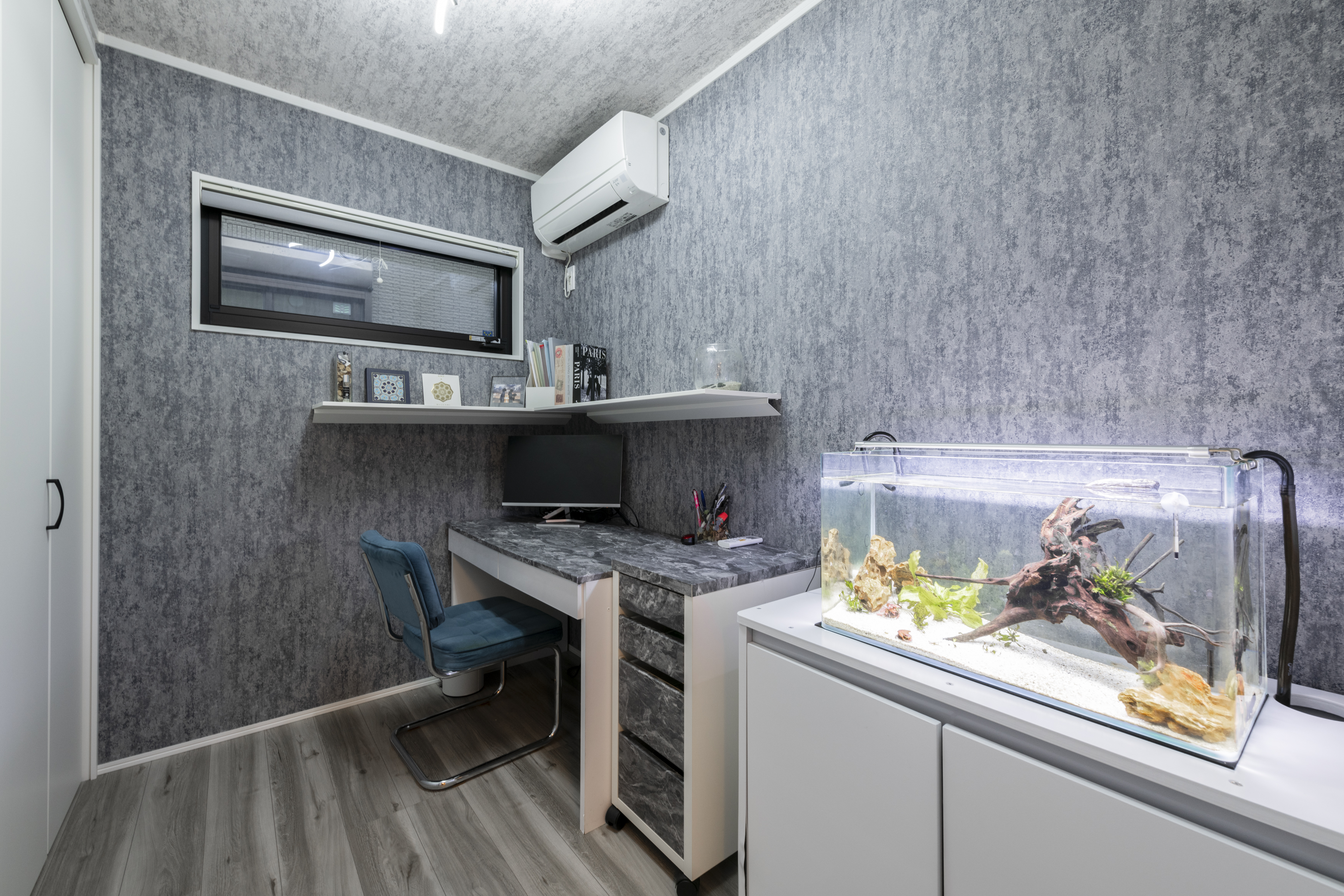 広島建設 セナリオハウス｜コンパクトな書斎スペースは、作業とくつろぎを両立させる設計。フィッシュタンクが癒しを与え、ダークトーンの壁紙が落ち着きを演出しています。お施主様の好きを詰め込んだ空間に。