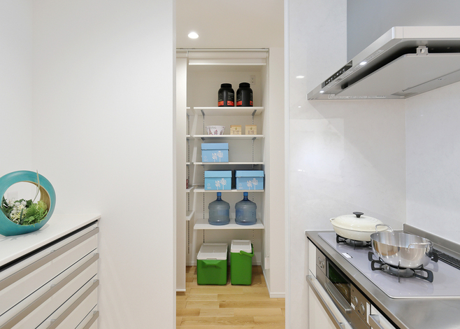 キッチン横はロールスクリーンで仕切るパントリーがある。十分な収納力でスッキリとしたキッチンを保つことができる