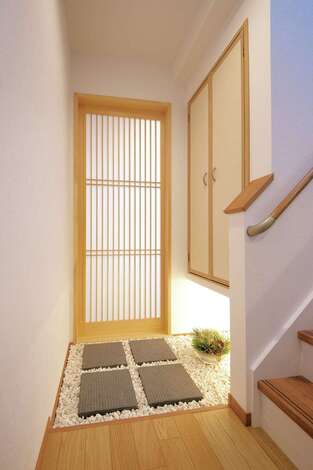 玉砂利と飛び石を敷いて京都の町家風に仕上げた客間。玄関からリビングを通らずに直接アクセスできるので、家族のプライバシーも確保できる