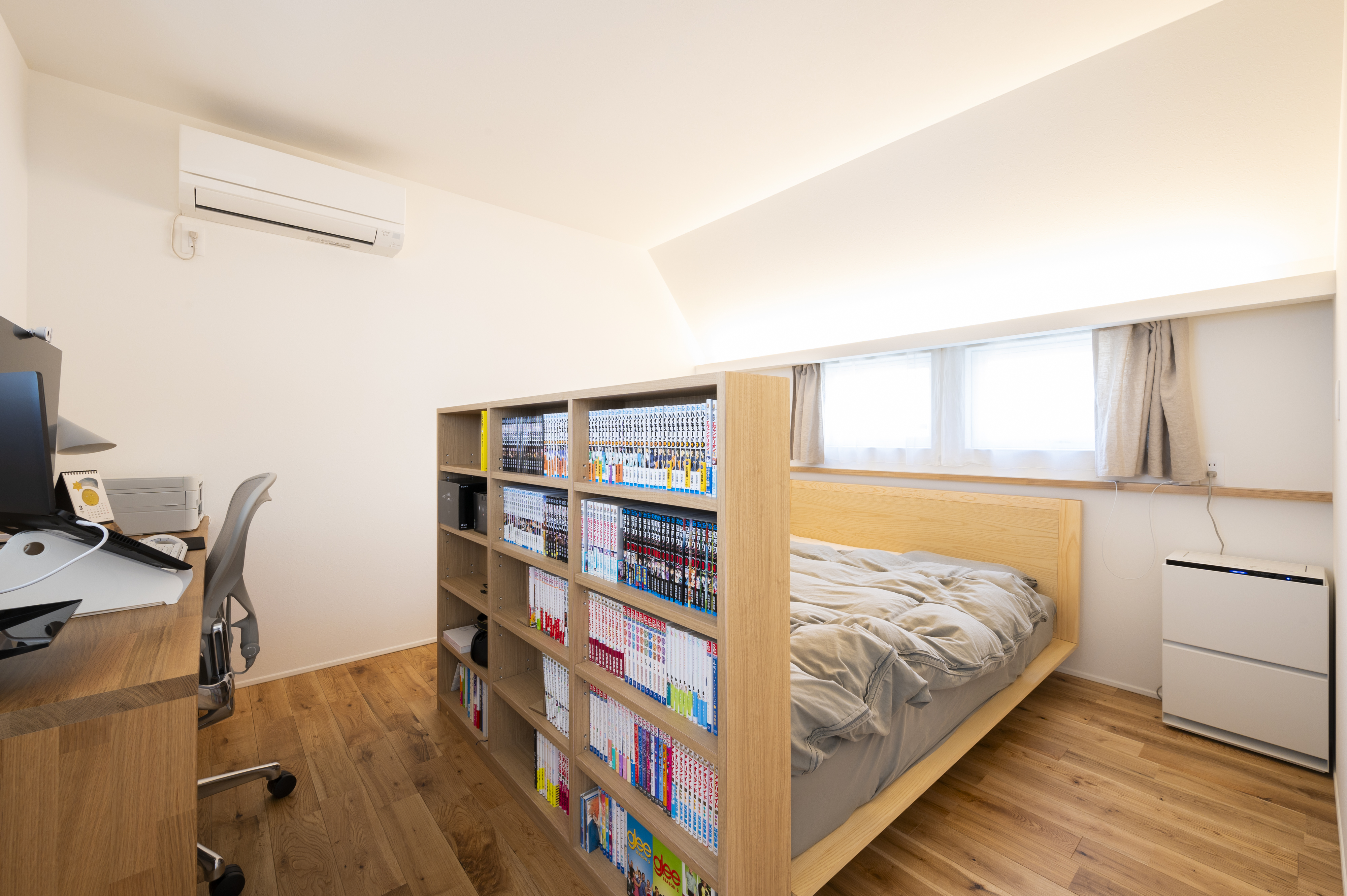 オネストアーク｜ベッドの足元に本棚を設置することで、寝室空間とワークスペース空間を分けることができます。
建具を用いて空間を仕切るよりも広く見せることができます。