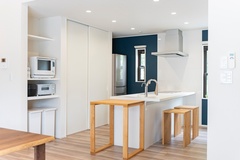 モダンなデザインのキッチン。広々としたスペースに、白を基調とした収納棚と機能的なカウンターが配置され、家事効率を高める。