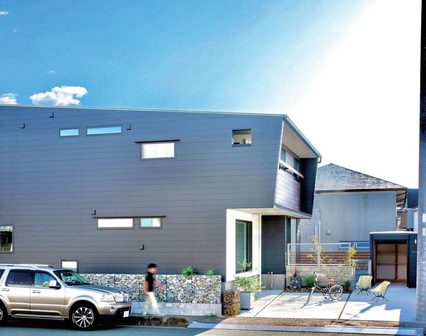 住たくeco工房【間取り、スキップフロア、ガレージ】メンテナンスの費用負担が少ないガルバリウム鋼板と、シャビーシックな風合いのSOLIDOを組み合わせたスタイリッシュな外観デザイン。庭の片隅に木製コンテナハウス「木箱mini」を設置して、アウトドアグッズを収納する