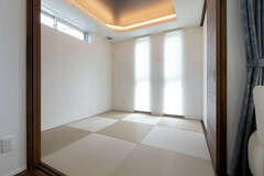 折上天井を設けて縦の広がりを強調した和室。周囲の視線に配慮して、窓の配置も工夫されている。折上天井に間接照明を仕込んでスタイリッシュな和モダン空間を演出