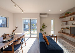 グリーンや小物使いにセンスが光るLDK。窓の外の風景と降り注ぐ自然光の印影が季節の移ろいを感じさせてくれる