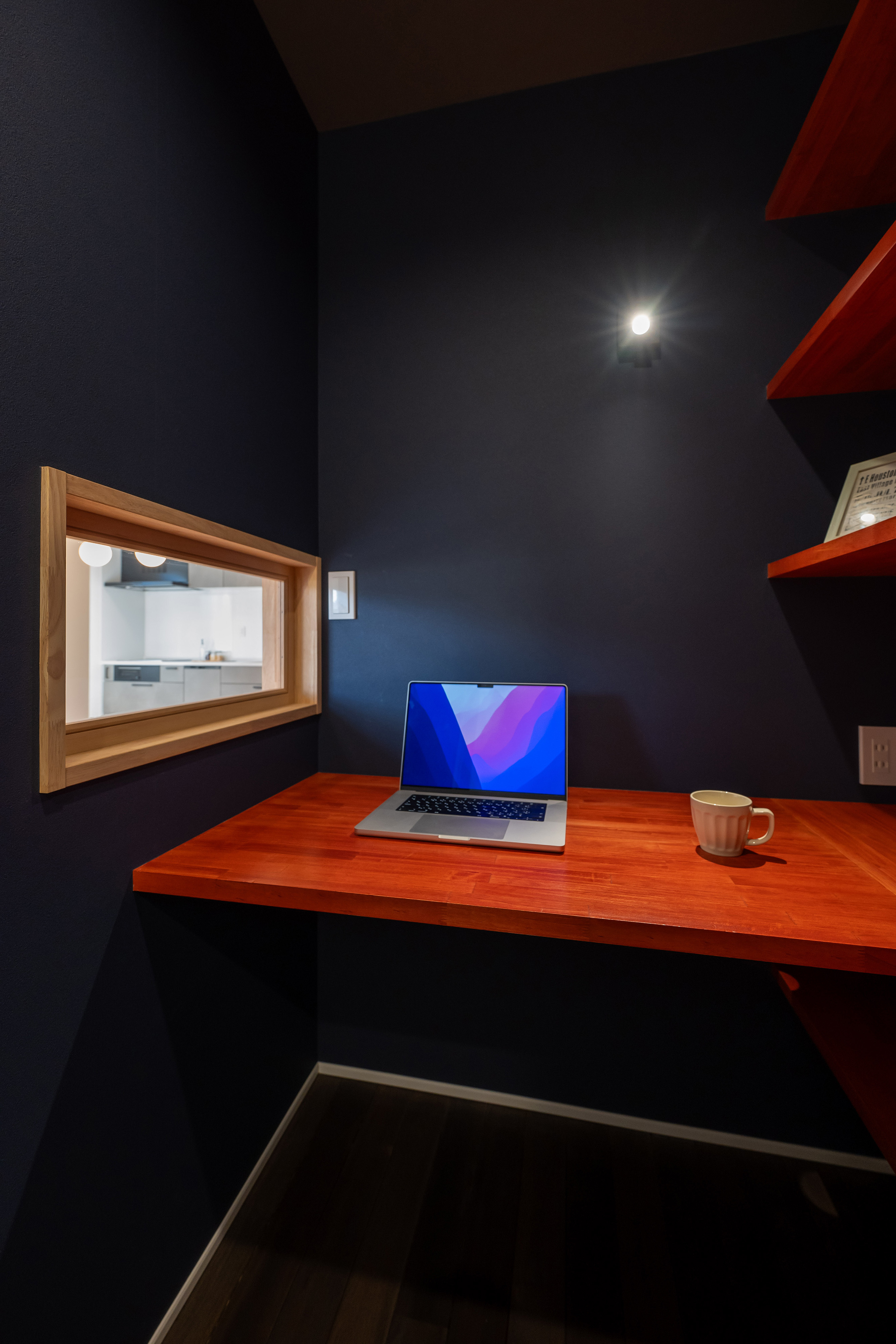 ハウスプラン（R＋house沼津・富士）【間取り、建築家、平屋】造作のデスクとたっぷりの本棚を備える、ご主人の書斎兼趣味室。ご家族とのつながりが保てるようLDKに向けた小窓が設えられた