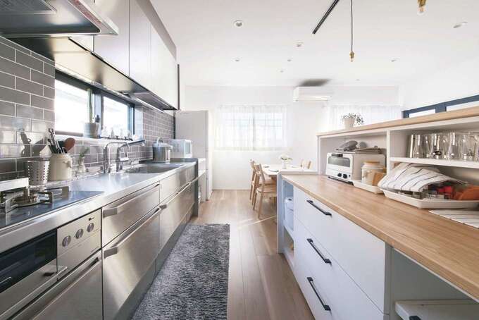 ステンレス製キッチンにグレーのタイル壁が映える