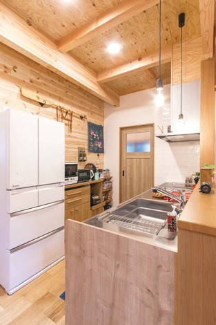 キッチンもウッディにして、リビングと同じトーンでまとめた。廊下につながる動線が便利